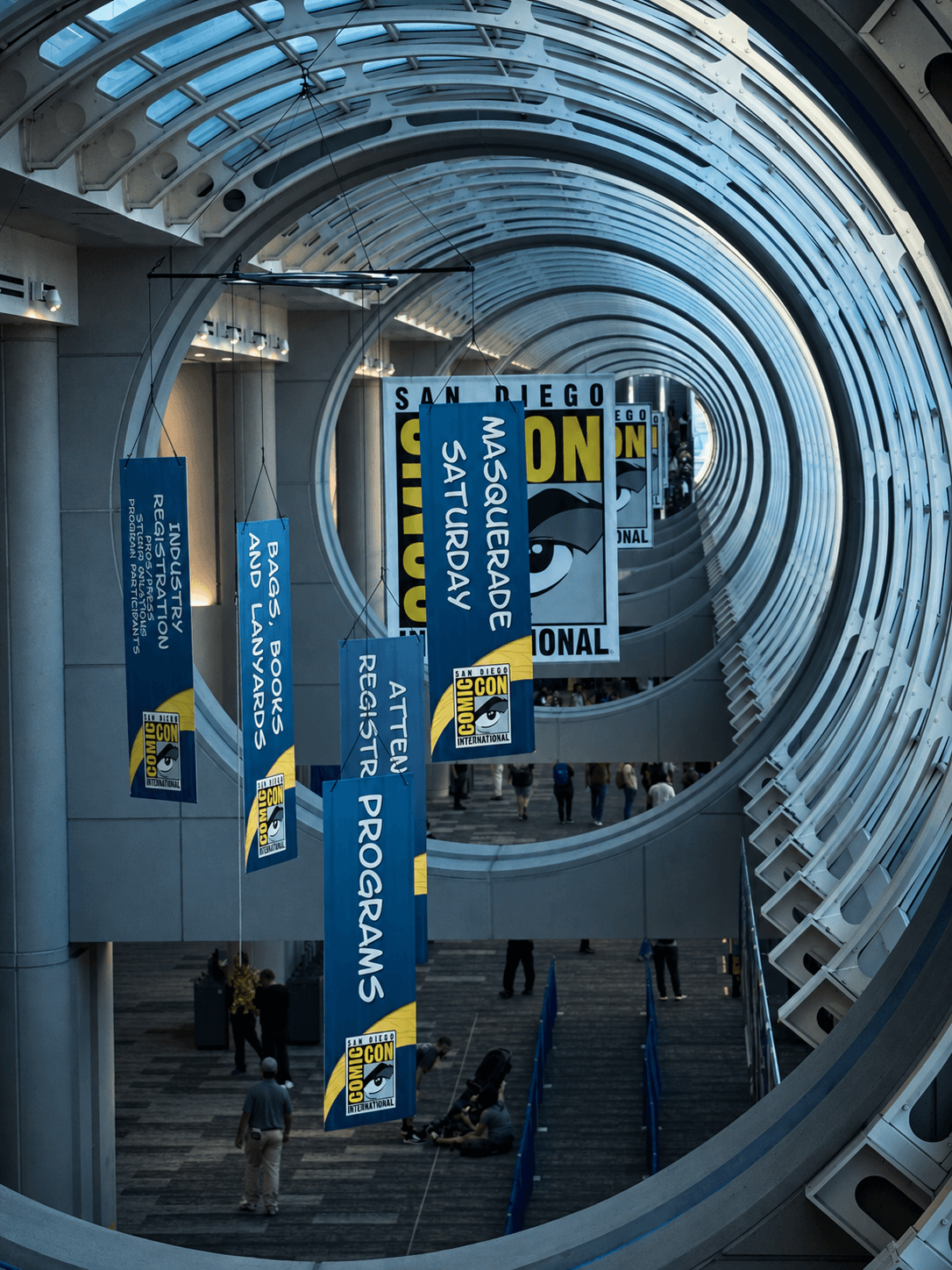 A convention hall with hanging banners and a glass walkway.