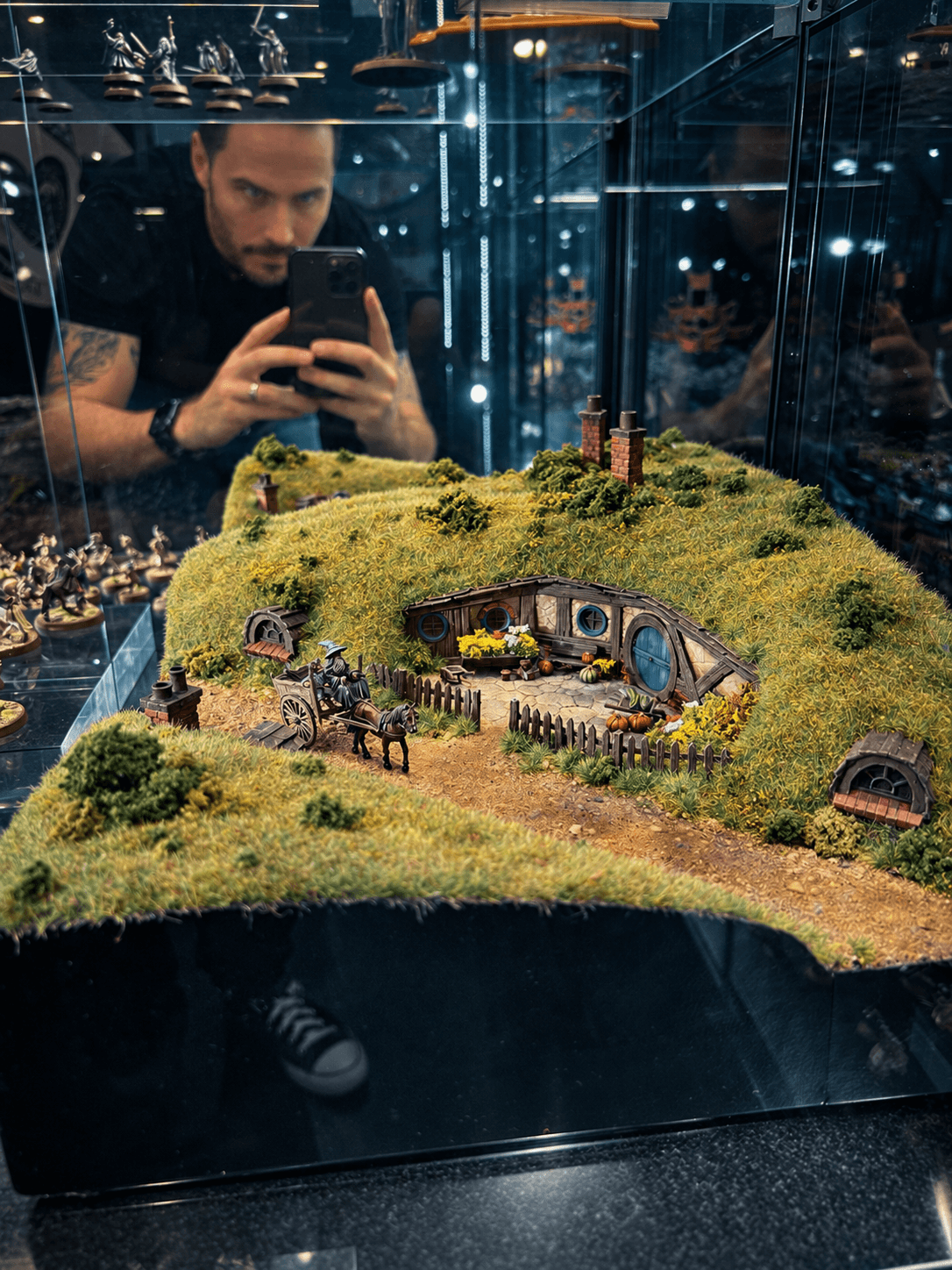 A painted miniature landscape in a glass display case.